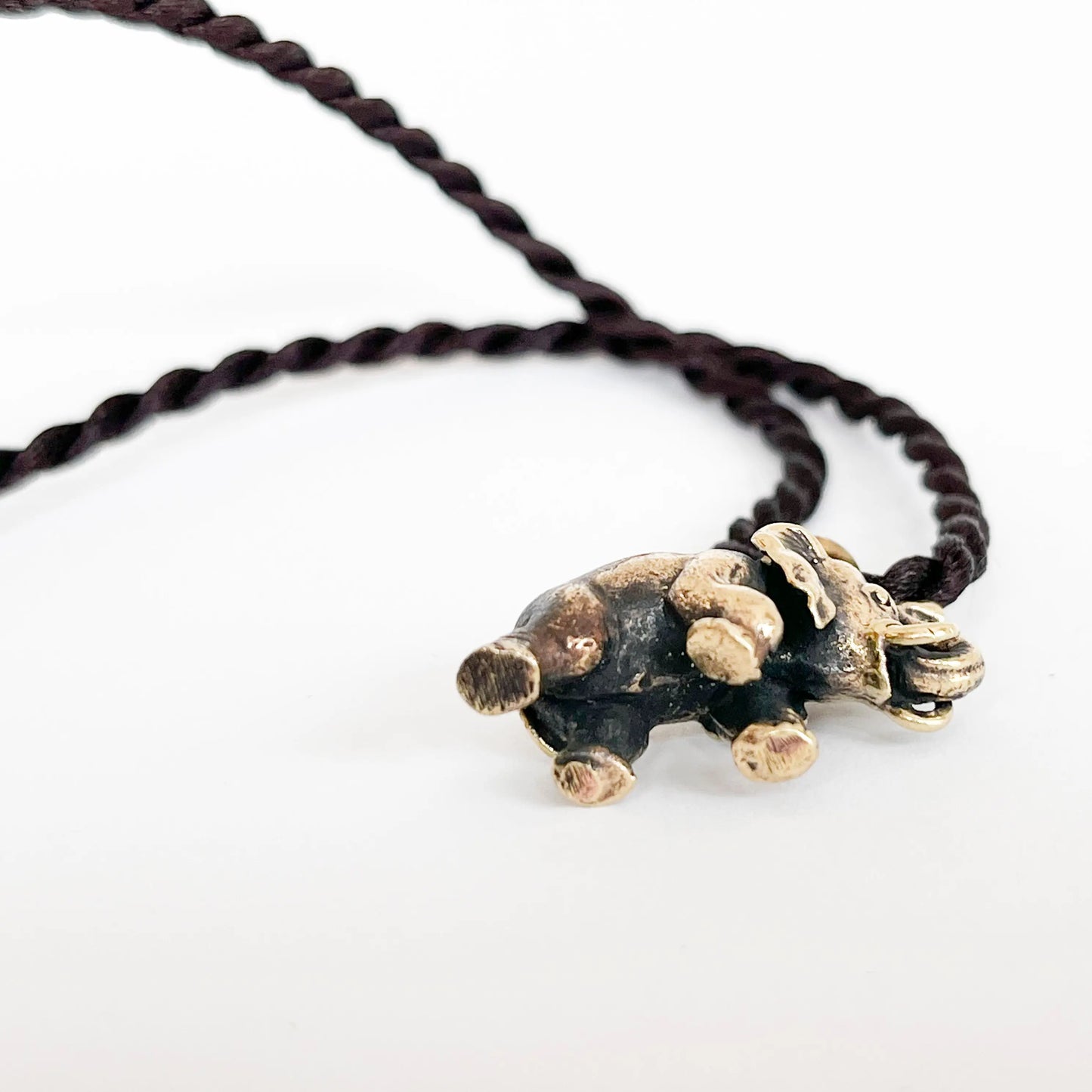 Brass elephant pendant with intricate details on twisted dark brown cord, Artschatz necklace. - Elephant Brass Pendant Necklace