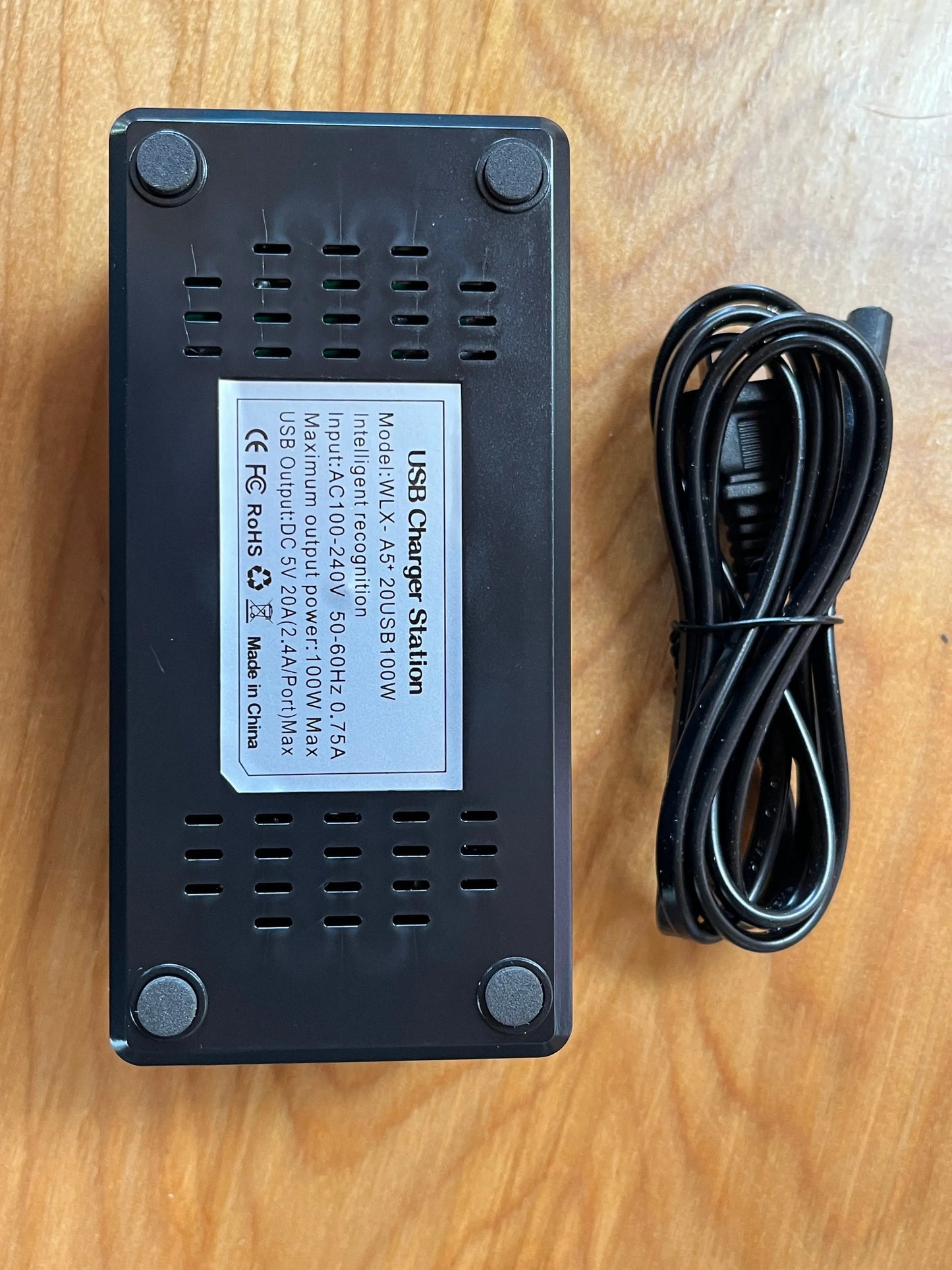 Artschatz black USB AC hub with 20 ports and power adapter cable on wood surface. - USB AC Hub - 20 Ports for Display