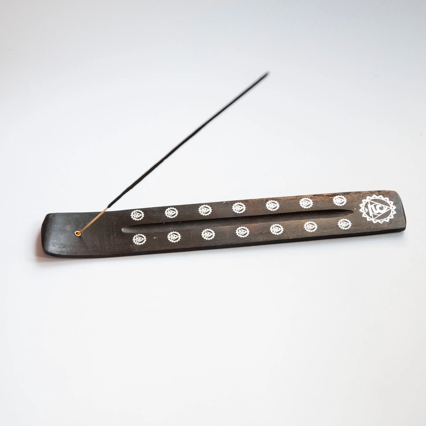 Black wooden Artschatz incense holder with white chakra symbols and burning incense stick. - Black Chakra