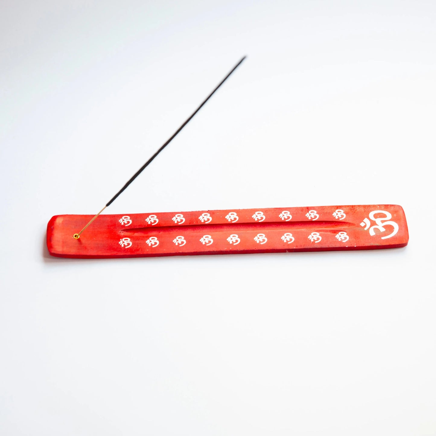 Red wooden Artschatz incense holder with white OM symbols and a burning incense stick. - Red OM